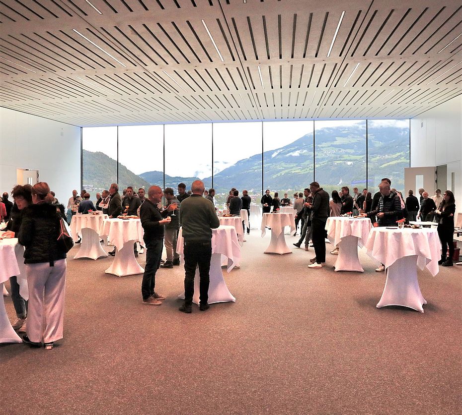 Networking-Event der Progress Group in modernem Veranstaltungssaal mit Bergpanorama